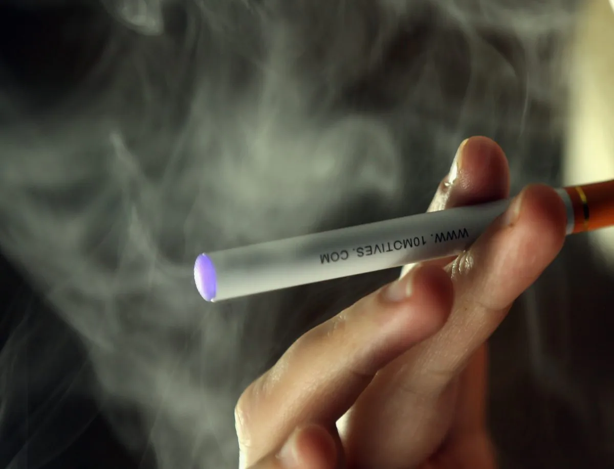In this photo illustration a woman smokes an electronic cigarette. Italian customers are switching to electronic cigarettes, putting pressure on traditional tobacco businesses.(Photo illustration by Christopher Furlong/Getty Images)