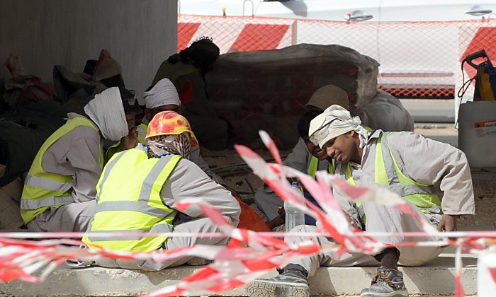 Asian labourers take a break during work on road network construction site in eastern Riyadh on April 7, 2013. Saudi Arabia has given illegal foreign workers a three-month grace period to legalize their status, after panic over reported mass deportations, an official statement said. (FAYEZ NURELDINE/AFP/Getty Images)
