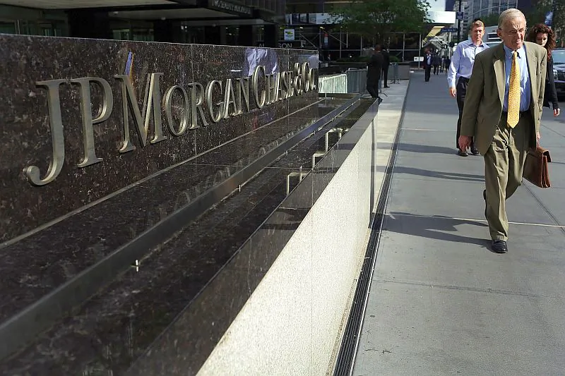People pass a sign for JPMorgan Chase & Co. at its headquarters in New York City in this file photo. Banking sector experts suggest that JPMorgan and other highly regarded financial institutions consider paying fines as a cost of doing business. (Spencer Platt/Getty Images)