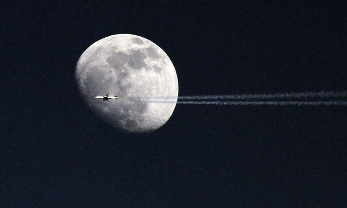An airplane passes in front of the moon over Philadelphia. A telescope that is set to launch to the moon in 2015 will allow the public to go on the Internet and view the Earth from the lunar surface. (AP Photo/ Joseph Kaczmarek)