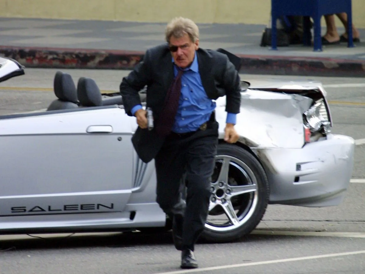 Actor Harrison Ford runs from the wreckage of car while filming a scene from his new movie 'Hollywood Homicide' on Hollywood Boulevard on October 22, 2002 in Los Angeles, California. Prop guns used on movie sets will not be banned by a new gun law in New York, but they will be regulated. (Ben-Ari Finegold/Getty Images)