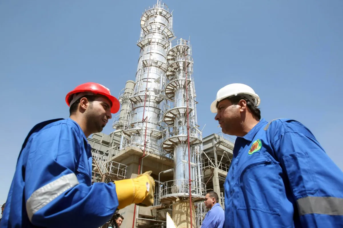 Iraqi workers stand outside the second refinery for crude oil in the Al-Dora refinery complex during its official opening ceremony in Baghdad on Sept. 16, 2010. A boom in oil investment and exports is fueling economic growth attracting foreign companies and capital. (Ahmad Al-Rubaye/AFP/Getty Images)