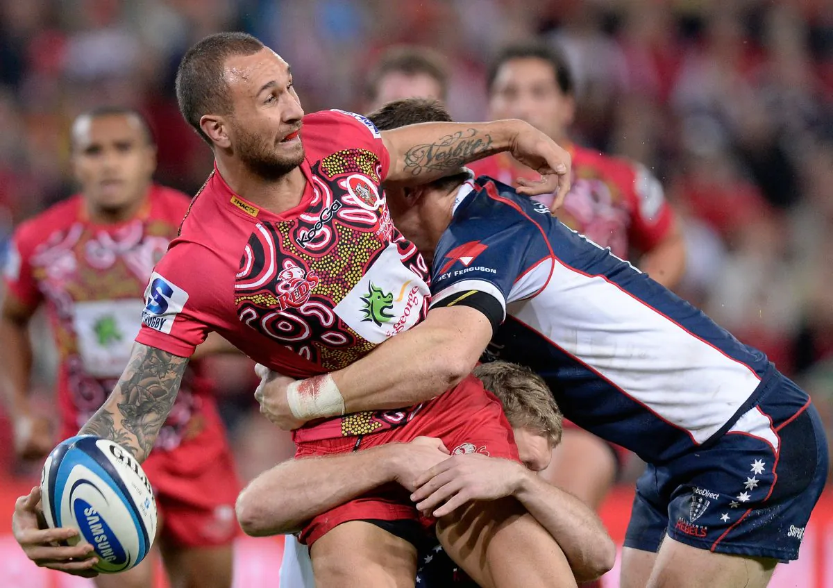 Under pressure, Quade Cooper passes, while playing for the Reds against the Rebels on Saturday June 1. (Bradley Kanaris/Getty Images)