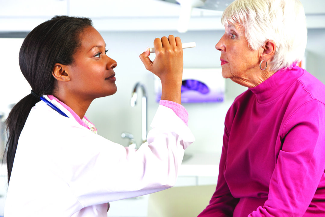 A doctor examines a patient in an ophthalmology laboratory. Eye floaters are those tiny flecks, spots, or cob-web-like structures that appear to drift aimlessly around in your field of vision. (Catherine Yeulet/photos.com)