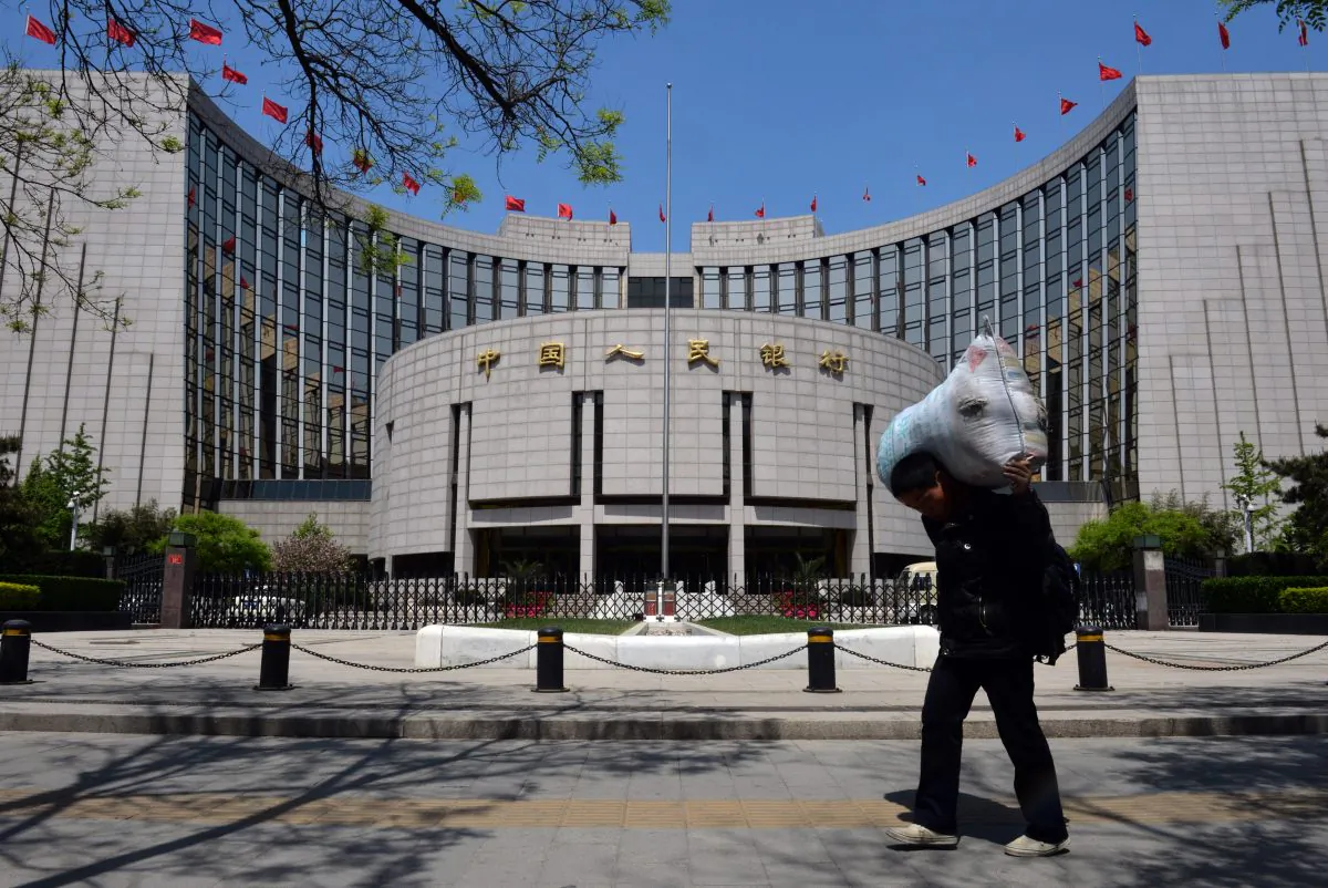 A Chinese migrant worker passes by The People's Bank of China (PBOC) as he heads to a bus station in Beijing on May 1, 2013. PBOC is China's central bank that regulates monetary policy and financial institutions. (Mark Ralston/AFP/Getty Images) 
