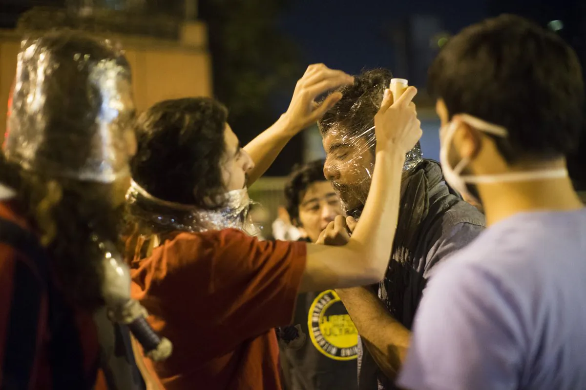 Protestors cover their faces with plastic during clashes with Turkish police near Turkish prime minister Recep Tayyip Erdogan office, between Taksim and Besiktas, early morning on June 4, 2013 in Istanbul, Turkey. The protests began initially over the fate of Taksim Gezi Park, one of the last significant green spaces in the center of the city. The heavy-handed viewed response of the police, Prime Minister Recep Tayyip Erdogan and his government's increasingly authoritarian agenda has broadened the rage of the clashes. (Uriel Sinai/Getty Images)