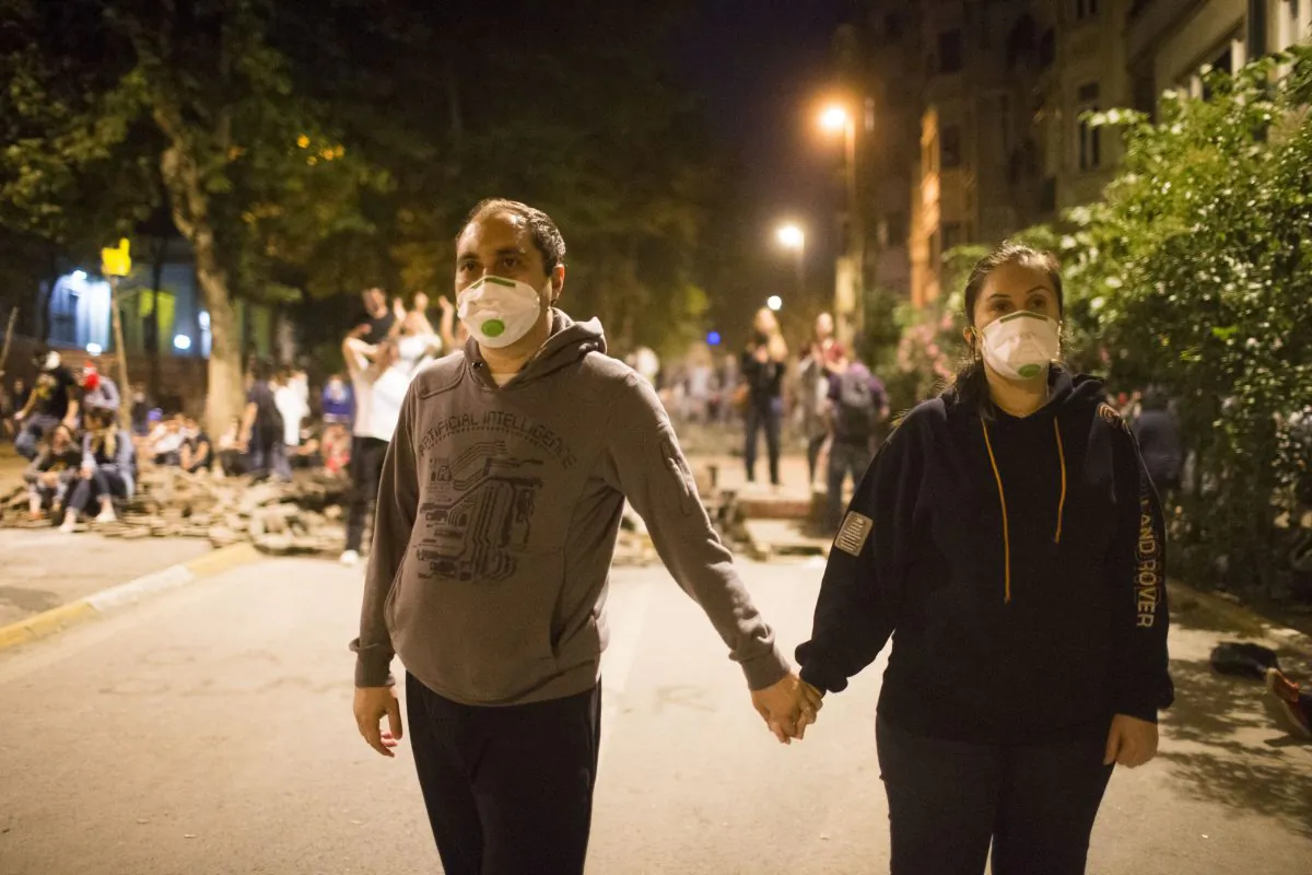 Protestors hold hands during clashes with police in Istanbul on Tuesday night (Uriel Sinai/Getty Images)