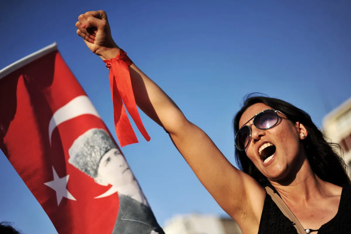 A protester raises her fist and shouts a slogan during a demonstration on Gundogdu Square in Izmir on June 9, 2013. (Ozan Kose/AFP/Getty Images)