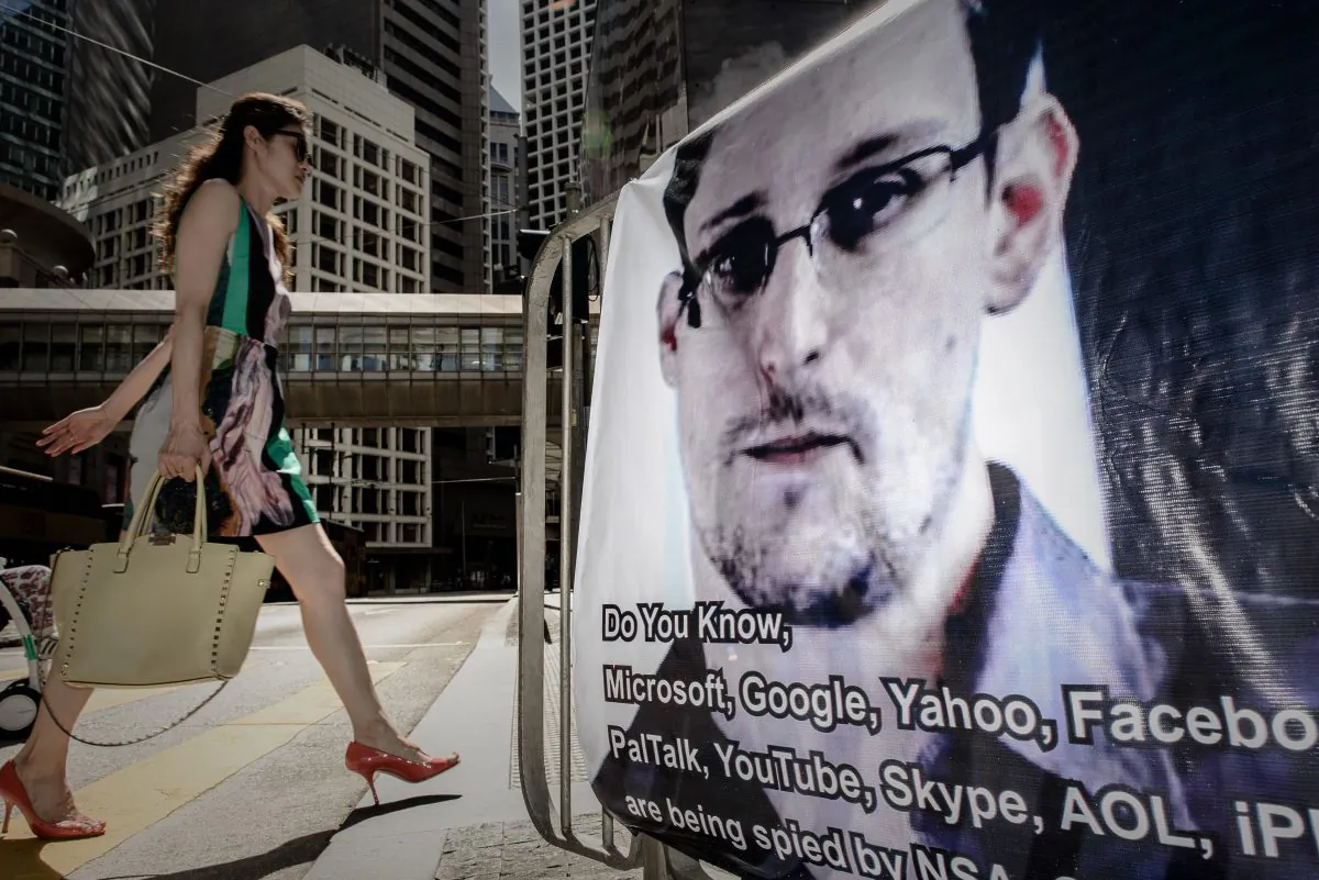 A woman walks past a banner displayed in support of former U.S. intelligence contractor Edward Snowden in Hong Kong on June 18, 2013. Snowden has recently begun revealing details of U.S. cyber operations against PRC-linked targets, a move that differs from the initial explanation he provided for why he was going public. (Philippe Lopez/AFP/Getty Images)
