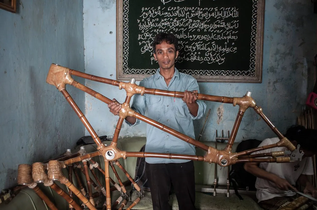 Gun Gun Gunawan poses with a tandem bamboo bike frame at Haur Bike workshop on June 19, 2013 in Bandung, Java, Indonesia. Two friends, Abah and Gun Gun Gunawan converted Abah's small guest room into a workshop in the Neglasari district in order to make bamboo bikes with sustainable phyllostachys aurea bamboo using DIY tools. They have named their product 'Haur Bike'. (Putu Sayoga/Getty Images)