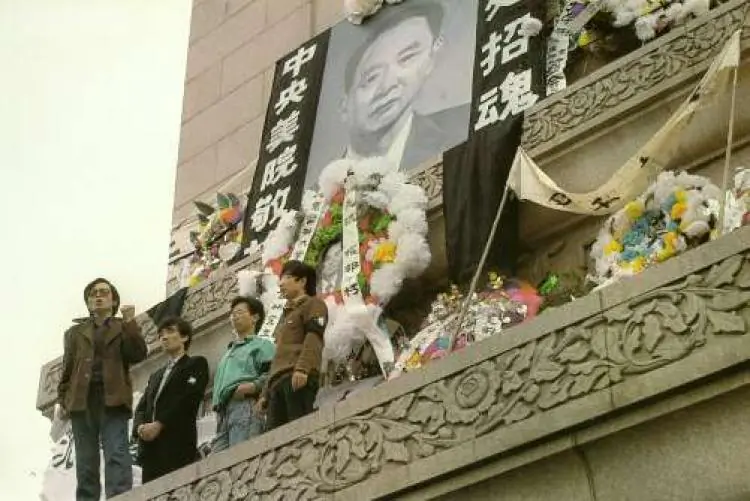 APRIL 18: Students hold aloft a banner calling for 'Freedom & Democracy Enlightenment' on the Martyr's Monument in Tiananmen Square festooned with a large portrait of Hu Yaobang, surrounded with wreaths dedicated to him by people from many universities. (64memo.com)