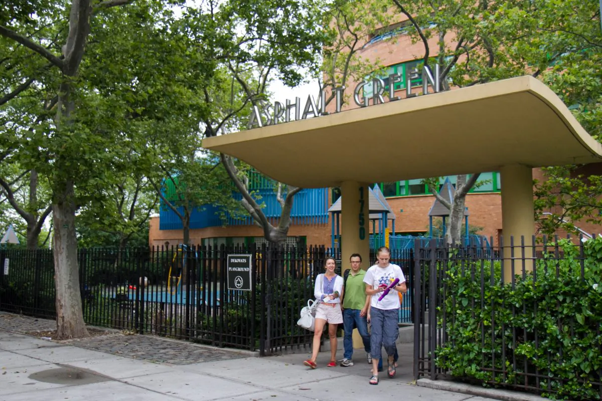 People walk out of the Asphalt Green Community Center on Manhattan’s Upper East Side, where the city’s proposed marine transfer station would be built—directly behind the center. (Benjamin Chasteen/The Epoch Times)