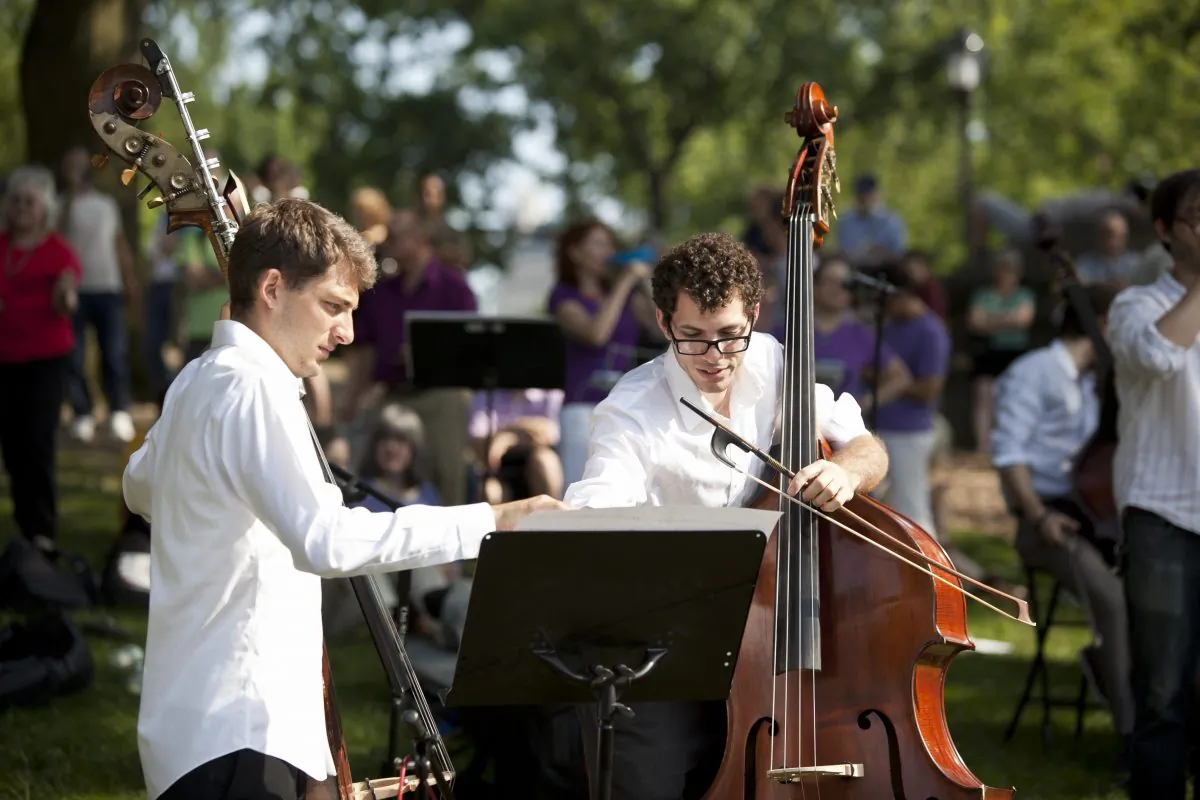 Double bass players get ready to perform in Central Park, June 22. (Samira Bouaou/Epoch Times)