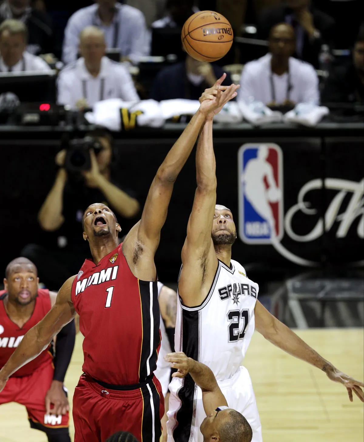 Miami Heat's Chris Bosh and San Antonio Spurs' Tim Duncan compete for the ball at tip off of Game 3 in their NBA Finals basketball series, Tuesday, June 11, 2013, in San Antonio. (AP Photo/David J. Phillip)