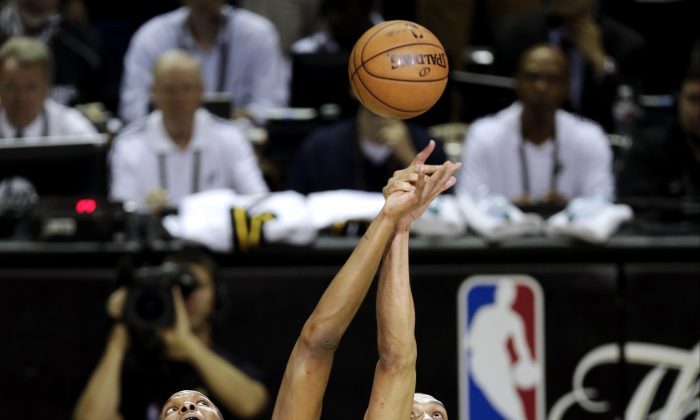 Miami Heat's Chris Bosh and San Antonio Spurs' Tim Duncan compete for the ball at tip off  of Game 3 in their NBA Finals basketball series, Tuesday, June 11, 2013, in San Antonio. (AP Photo/David J. Phillip)