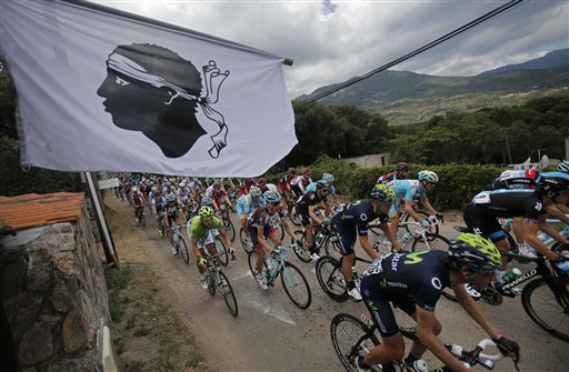 The pack passes a flag featuring a Moor's head, the Corsican emblem, during the first stage of the 100th edition of the Tour de France cycling race over 213 kilometers (133 miles) with start in Porto Vecchio and finish in Bastia, Corsica island, France, Saturday June 29, 2013. (AP Photo/Christophe Ena)