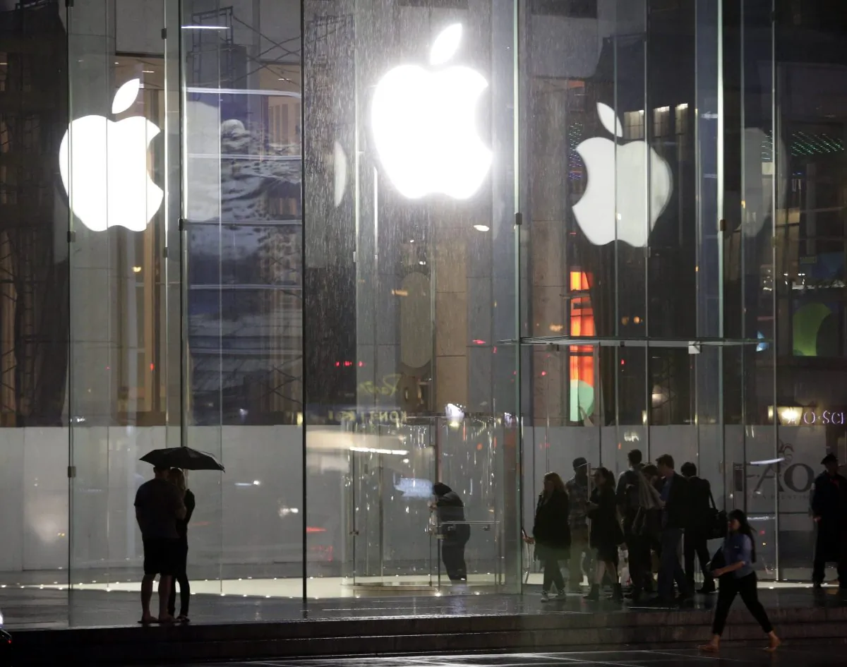 Pedestrians pass the Apple store location on fifth avenue Thursday, June 6, 2013, in New York. The United States is investigating a possible price fixing of E-Books in Apple's favor. (AP Photo/Frank Franklin II)
