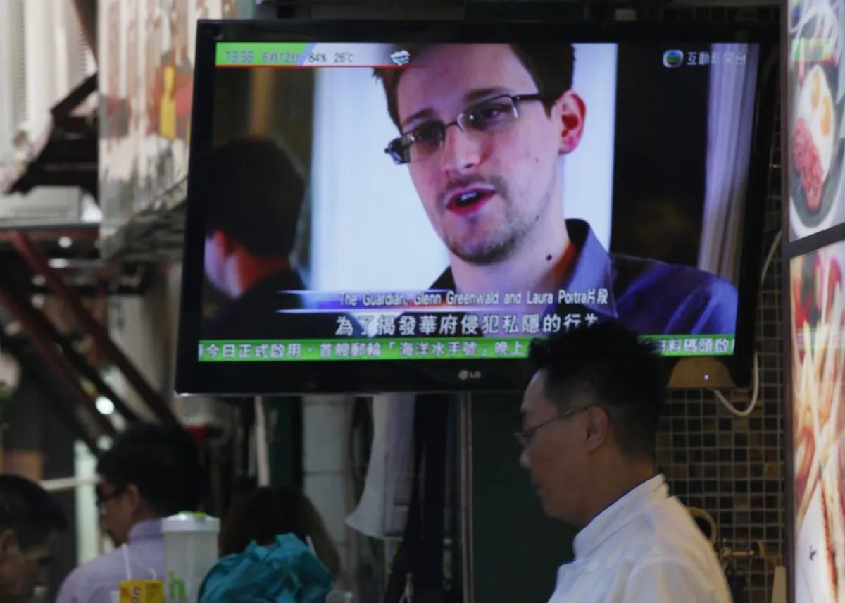 A TV screen shows the news of Edward Snowden, former CIA employee who leaked top-secret documents about sweeping U.S. surveillance programs, at a restaurant in Hong Kong on Wednesday, June 12, 2013. Snowden's disclosure of the NSA documents has been a propaganda windfall for the Chinese regime. (AP Photo/Kin Cheung) 