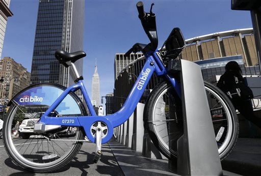 Pedestrians pass a bicycle available as part of the Citi Bike sharing program Wednesday, June 5, 2013, in New York. Authorities say those people using New York City's new bike-sharing program have logged more than a million miles in less than a month. (AP Photo/Frank Franklin II)