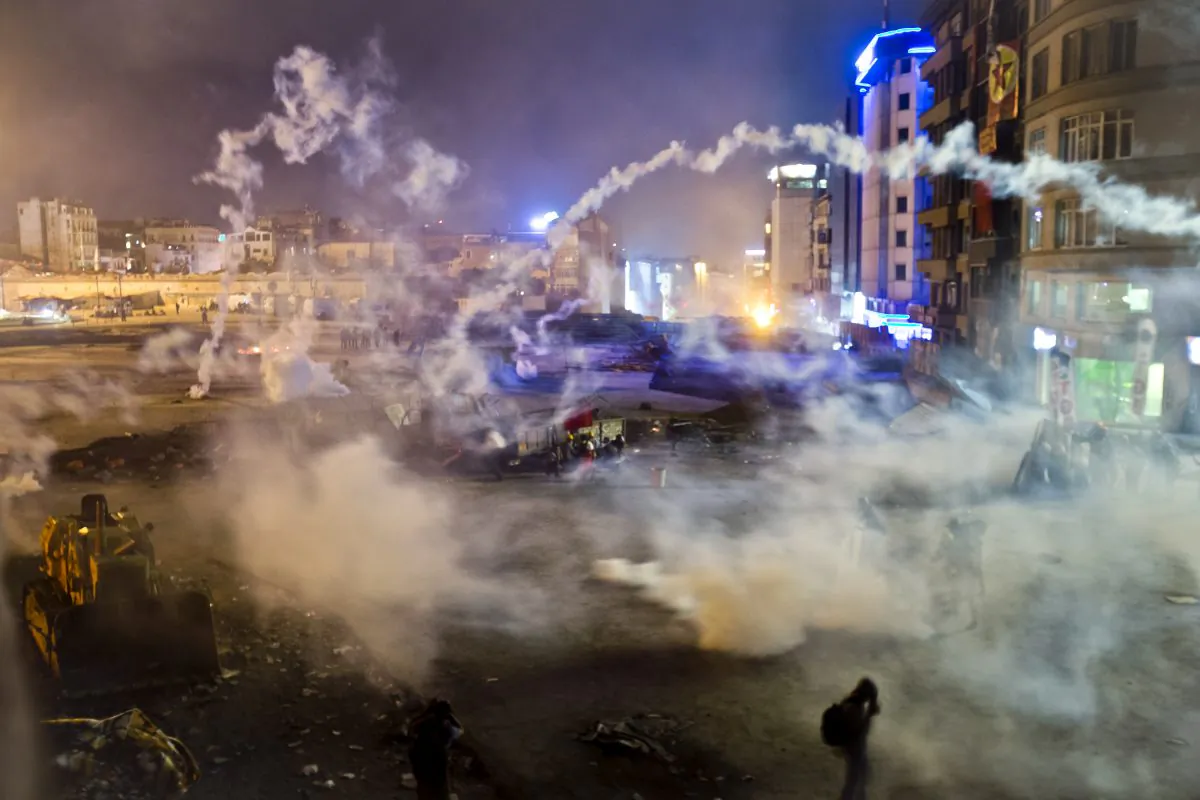 Taksim Square is flooded by tear gas as clashes between protesters and riot police continue into the night in Istanbul Tuesday, June 11, 2013. Hundreds of police in riot gear forced through barricades in the square early Tuesday, pushing many of the protesters who had occupied the square for more than a week into a nearby park. (AP Photo/Vadim Ghirda)