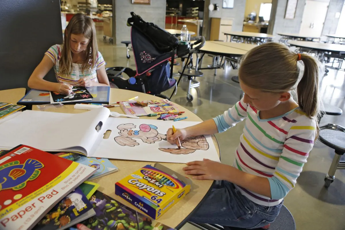 Brook Cramer, right, 9, and her sister Taylor, 11, color at the American Red Cross shelter in Monument, Colo., for evacuees from the nearby Black Forest wildfire on Friday, June 14, 2013. The sisters are among nearly 4,000 people are still evacuated from the fire that broke out on Tuesday. (AP Photo/Ed Andrieski)