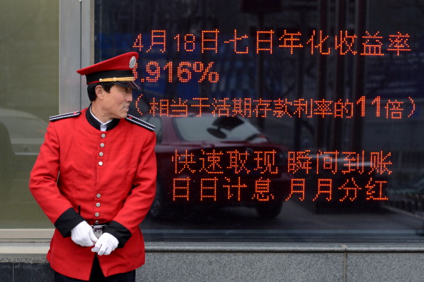 A guide stands in front of a bank in Beijing on April 23, 2013. (Wang Zhao/AFP/Getty Images)
