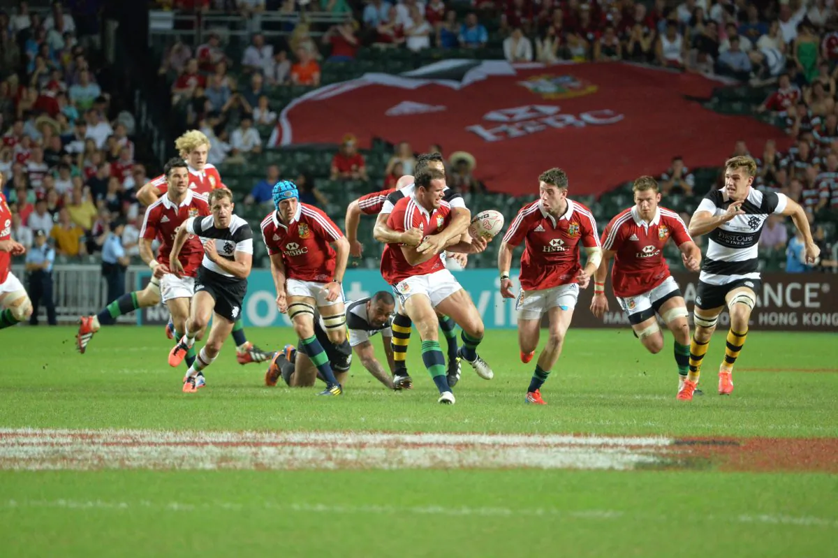Sultry warm-up for the Australian Tour ... British and Irish Lions Jamie Roberts hands off the ball to Alex Cuthbert as the team surges forward early in their match against the Hong Kong Barbarians at Hong Kong Stadium on Saturday June 1. (Bill Cox/The Epoch Times)