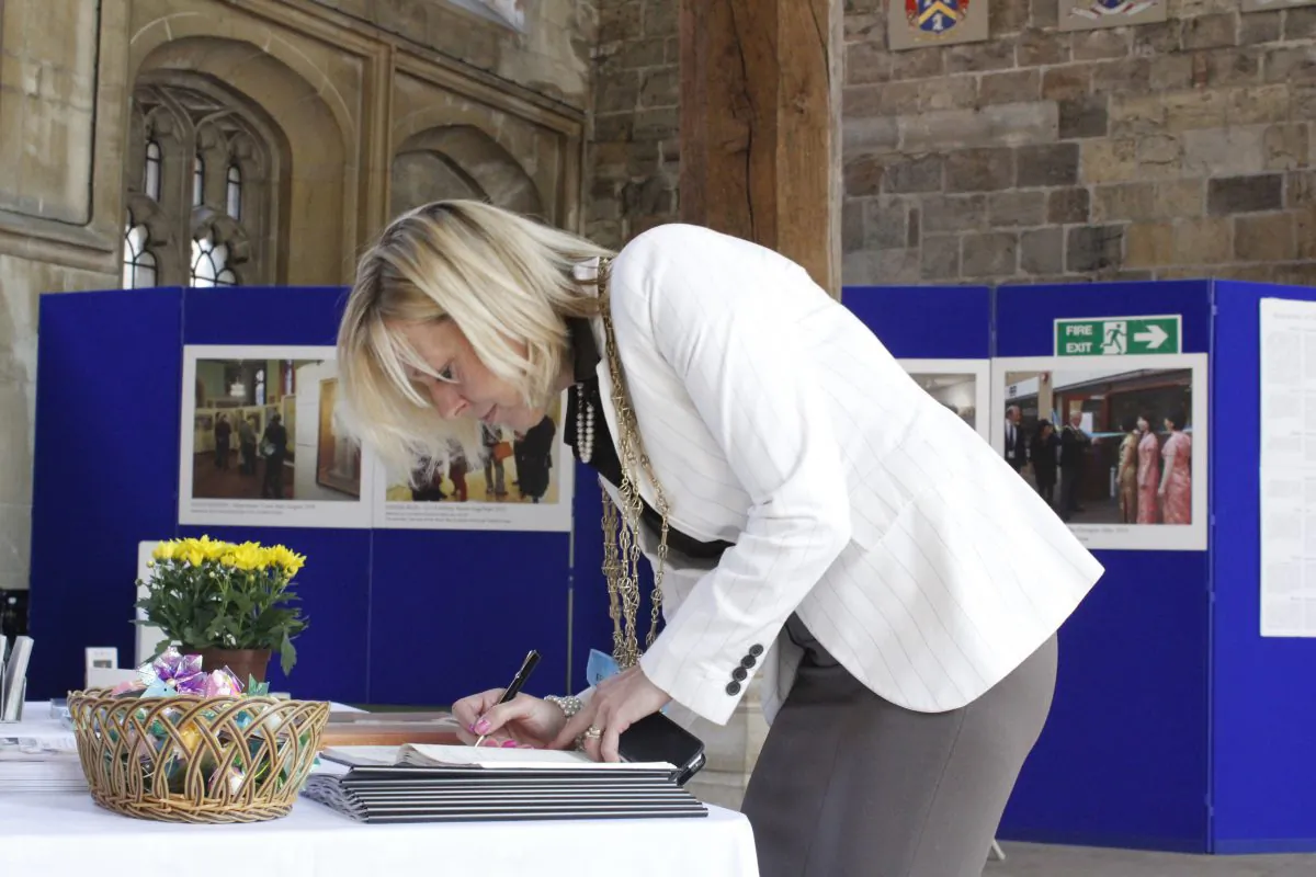 Lord Mayor of York, Councillor Julie Gunnell, writes in the visitors book at The Art of Zhen Shan Ren Exhibition in the Guildhall of her native York, on June 7, 2013. (Lingsoong Wong)