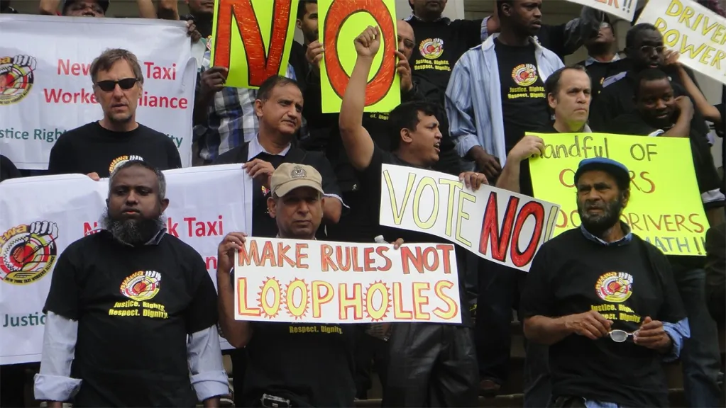 Protesters hold signs and shout outside the New York City Hall on June 11 to urge the city administration to turn down new rules by the Taxi and Limousine Commission. (Courtesy New York Taxi Workers Alliance)