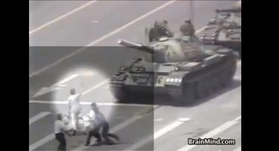 A screen grab from a video shot of the Tank Man shows two plain clothes police grabbing him and starting to hustle him off the boulevard.