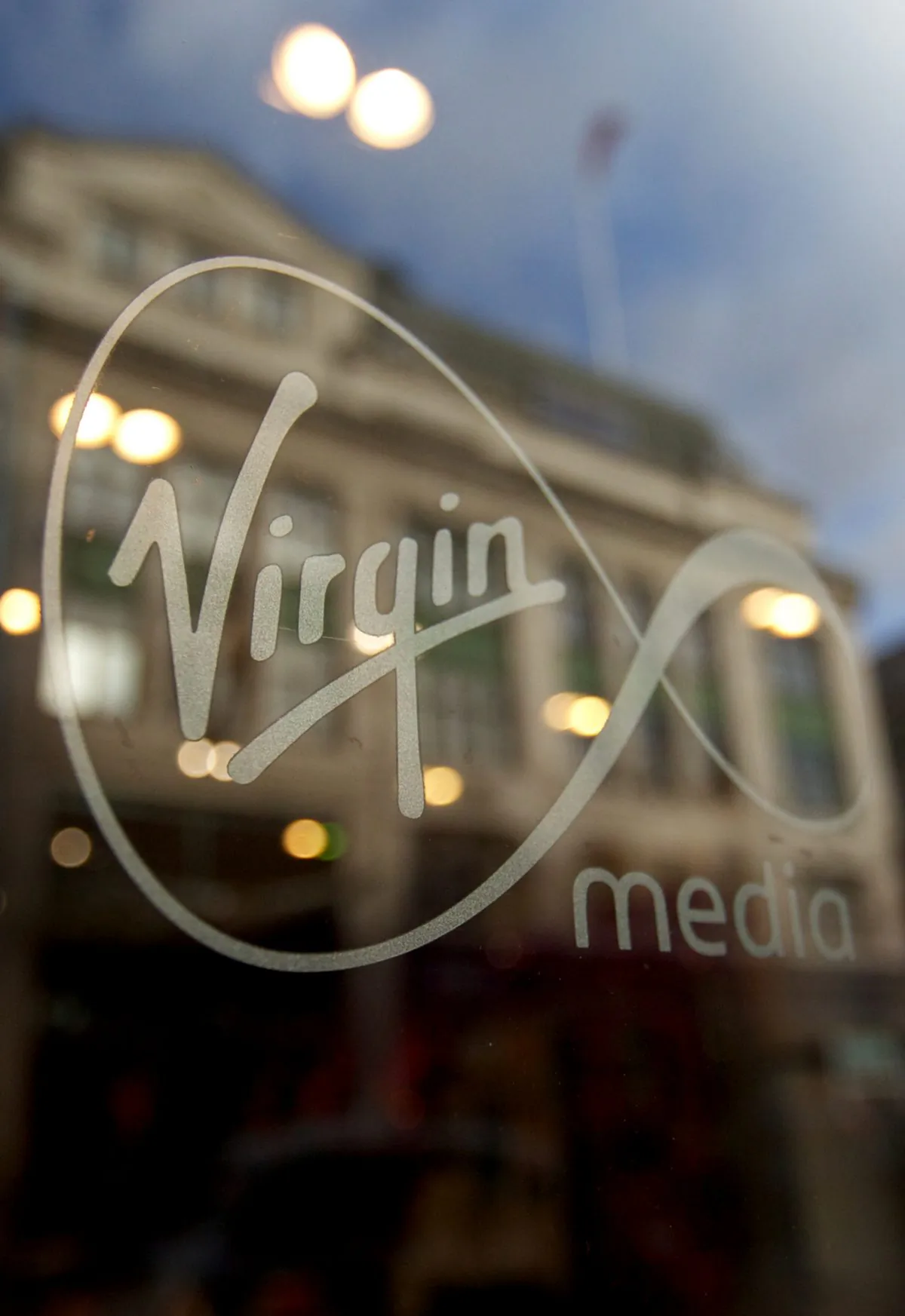 A Virgin Media logo is displayed in the window of the company's shop on Oxford Street in central London on Feb. 6, 2013. US-based cable operator Liberty Global completed an acquisition of Virgin Media on June 7, 2013, and Virgin Media withdrew from the London Stock Exchange on June 10, 2013. (Andrew Cowie/AFP/Getty Images)