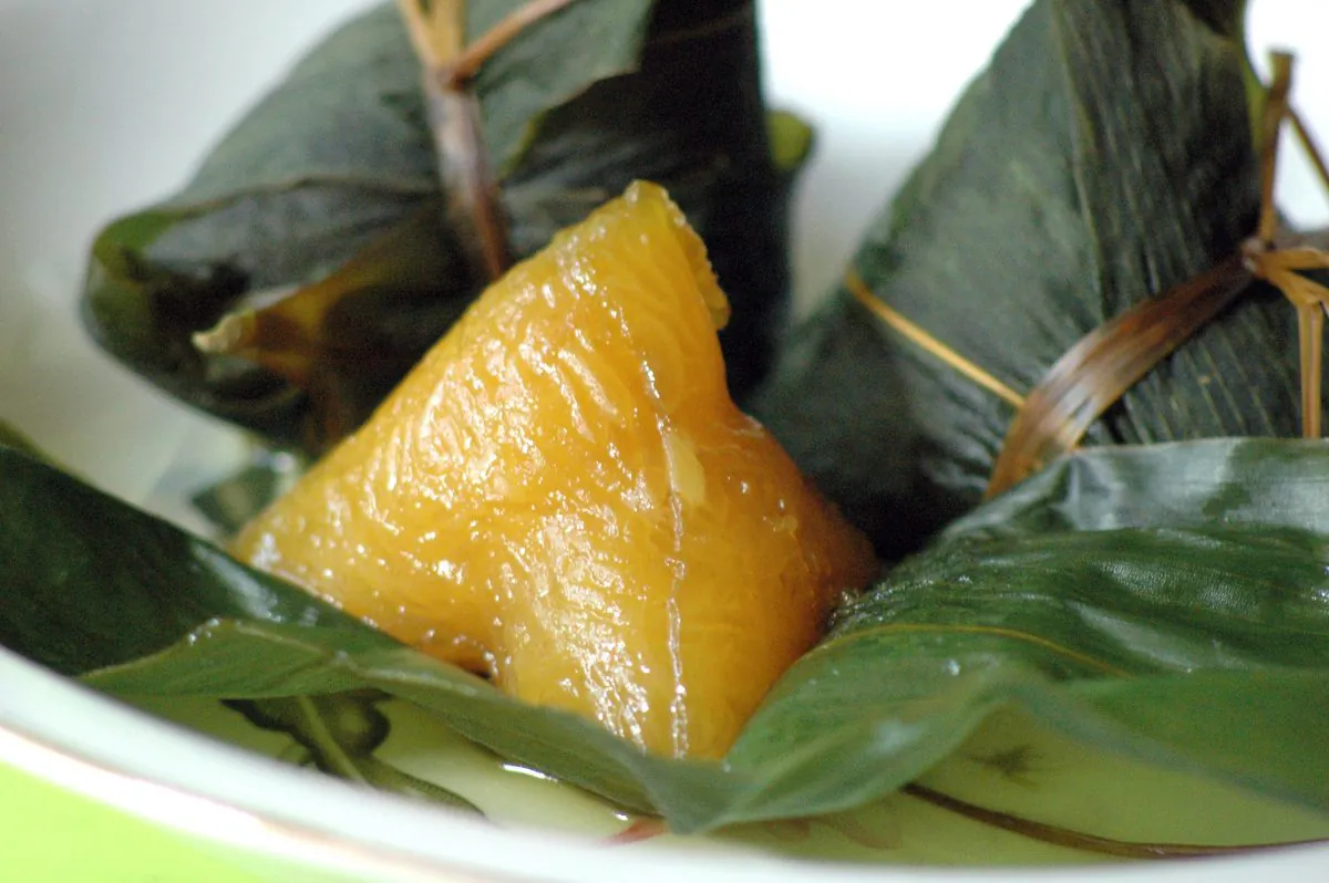 Eating the steamed rice,
leaf-wrapped packages, zongzi, is an important custom during the Dragon Boat Festival. (The Epoch Times)