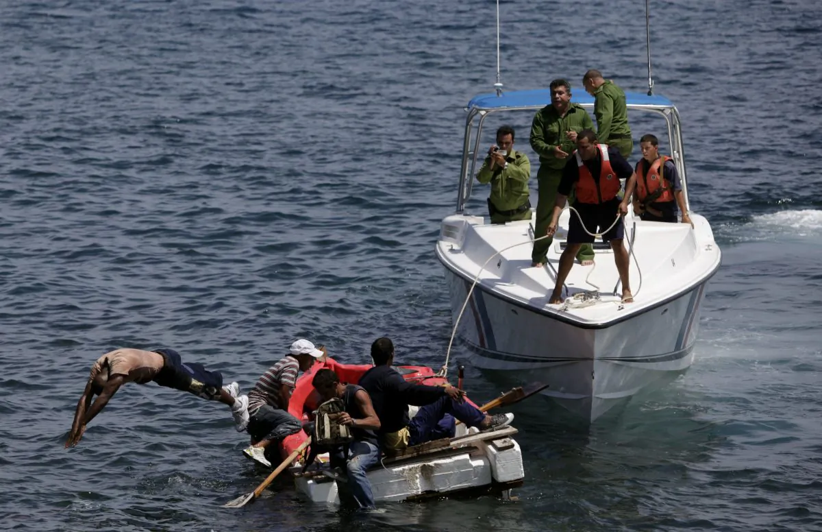 In this June 4, 2009 file photo, Cuban coast guards, right, stop seven men trying to migrate illegally to the U.S. on a foam raft near Havana's Malecon.  No one was arrested, according to police. (AP Photo/Javier Galeano)