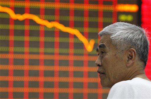 A stock investor watches a board displaying stock prices at a brokerage house in Huaibei in central China's Anhui province Monday June 24, 2013. Numerous rumors about bank defaults and glitches as well as bad economic data have pushed stocks in China in bear market territory. (AP Photo)