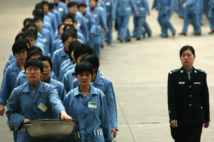 Prisoners walk beside a police escort during a prison open day in Nanjing, 2005. (STR/AFP/Getty Images)