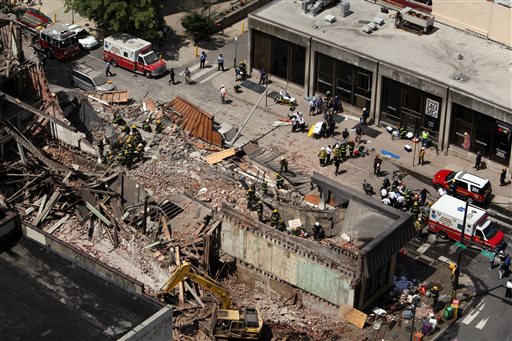Rescue personnel work the scene of a building collapse in downtown Philadelphia, Wednesday, June 5, 2013. A four-story building being demolished collapsed Wednesday on the edge of downtown, injuring 12 people and trapping two others, the fire commissioner said. Rescue crews were trying to extricate the two people who were trapped, and the dozen people who were injured were taken to hospitals with minor injuries, according to city Fire Commissioner Lloyd Ayers. (AP Photo/Jacqueline Larma)