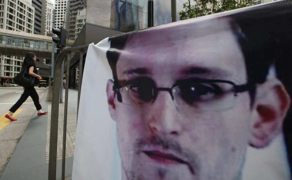 A banner of Edward Snowden, the former CIA employee who leaked top-secret documents about U.S. surveillance programs, is displayed at Central, Hong Kong's business district, Thursday, June 20, 2013.  Snowden has been charged with espionage on June 21. (AP Photo/Kin Cheung)
