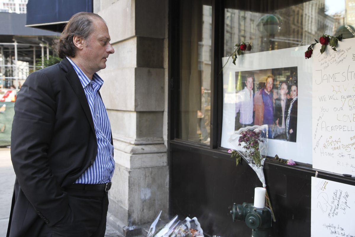 Sergio Acappella looks at a shrine set up for the late Sopranos actor James Gandolfini outside of his Tribeca restaurant on June 24. Gandolfini was a regular at Acappella. (Amelia Pang/Epoch Times)