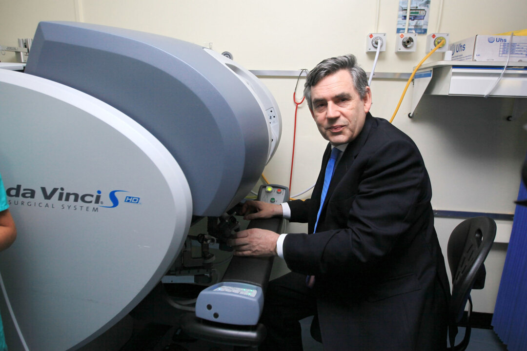 Former prime minister Gordon Brown takes to the controls of a surgical robot used to treat prostate cancer during his visit to Christie's Hospital, one of Europe's leading cancer centres, on July 3rd, 2009 in Manchester, England. (Christopher Furlong/Getty Images)