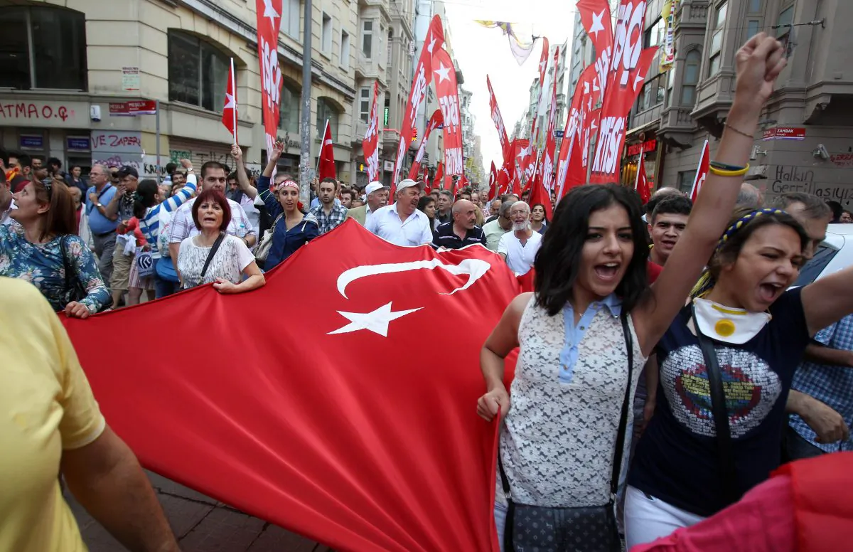 Protesters shout slogans as they hold a Turkish flag during the third day of nationwide anti-government protest at the Taksim square in Istanbul, June 2, 2013. Fierce clashes have followed a police crackdown on a peaceful gathering, as protesters denounced what they see as Prime Minister Recep Tayyip Erdogan's increasingly authoritarian style. (AP Photo/Thanassis Stavrakis) 