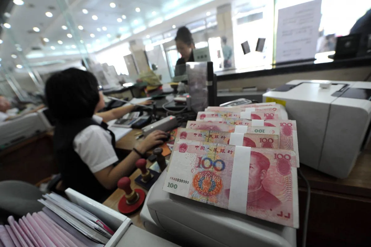 A Chinese bank worker attends to a customer with stacks of 100-yuan notes at a bank counter in Hefei, east China's Anhui province on September 30, 2010. A liquidity crunch in the Chinese banking system has led to speculation about what it means for China's economic trajectory. (STR/AFP/Getty Images)
