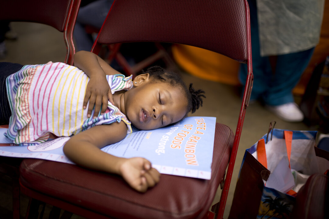 Two-year-old Alana Marie sleeps as her mother waits for care at the fourth annual free health clinic at the Los Angeles Sports Arena in Los Angeles September 2012. Poor people face barriers to medical care, and choose emergency rooms over primary doctors, according to a recent study. (ROBYN BECK/AFP/GettyImages)
