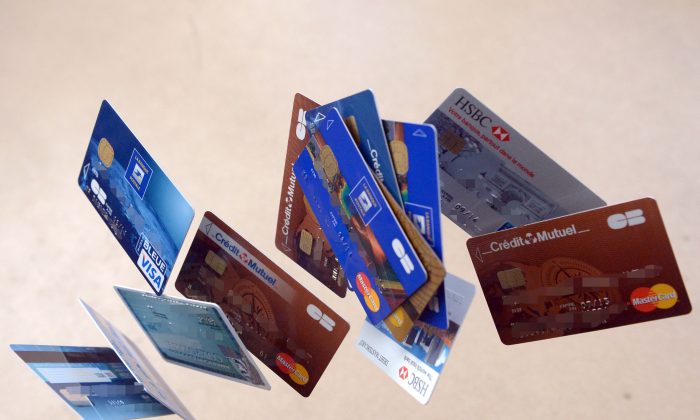 Payment cards falling down are pictured in this photo montage. In the United States, pre-paid debit cards are becoming ever more popular, but they carry certain drawbacks. (Damien Meyer/AFP/Getty Images)