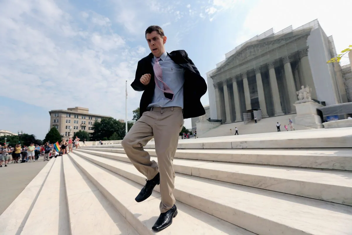 Intern Dan Stein runs with news of a recent ruling in front of the U.S. Supreme Court building in Washington, D.C., June 24. Recent statistics show close to two-thirds of students from the graduating Class of 2013 worked as interns, 47.8 percent of them for free.
(Win McNamee/Getty Images)