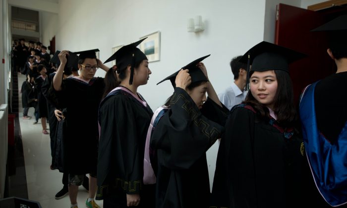 Students line up to receive their degree certificates at the private Kade College Capital Normal University on the outskirts of Beijing on June 26, 2013. Only 43 full-time private institutes and 24 part-time institutes of higher education in Beijing are legally registered to offer degrees. (Ed Jones/AFP/Getty Images)