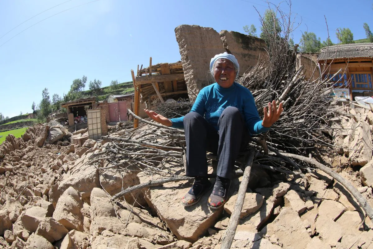 A resident cries on her collapsed house in Hetuo Township in Dingxi, northwest China's Gansu province on July 22, 2013. Double tremors killed 73 people and injured almost 600, officials said. (STR/AFP/Getty Images) 