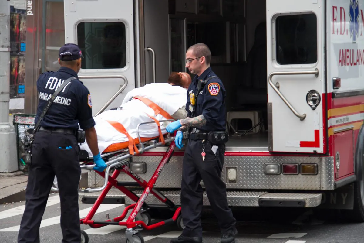FDNY paramedics prepare to lift a man on a stretcher to an ambulance in New York City on Oct. 4, 2012. To deal with the city’s heat wave, the FDNY dispatched an additional 14 ambulances, but Council Speaker Christine Quinn suggested it was not enough after waiting 31 minutes for an ambulance to pick up an intern on July 16. (Benjamin Chasteen/Epoch Times)