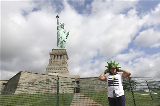 Leticia Baes, of the Phillipines, poses for a photo at the bases of the Statue of Liberty, Thursday, July 4, 2013 at in New York. The Statue of Liberty on the Fourth of July . (AP Photo/Mary Altaffer)