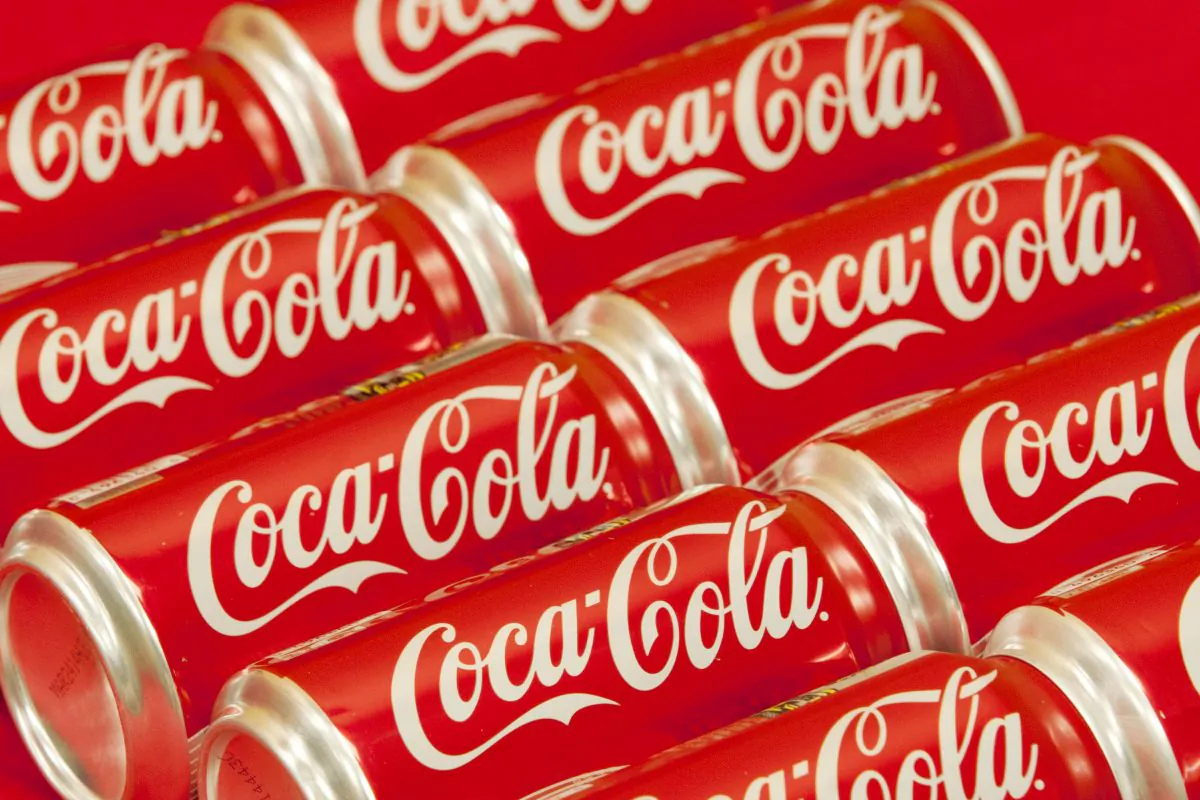 In this Monday, July 15, 2013 photo, bottle tops of Coca-Cola 8 oz. bottles are shown in Doral, Fla. The Coca-Cola Co. reports quarterly financial results before the market opens on Tuesday, July 16, 2013. (AP Photo/Wilfredo Lee)