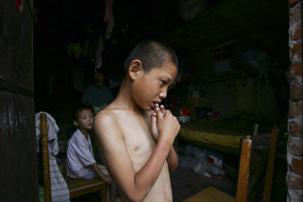 A mentally handicapped child waits to get dressed after bathing at the Wang Jiayu Orphanage which was set up by a farmer in Sanshilipu Village of Anhui Province, China. (China Photos/Getty Images)